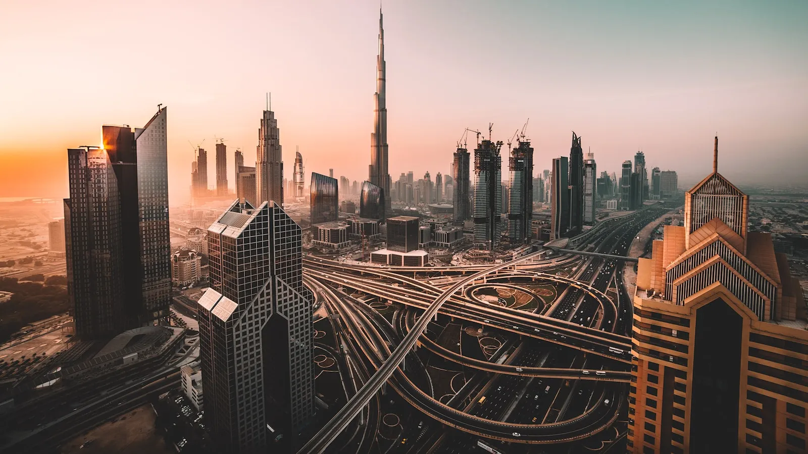 The Burj Khalifa and skyscrapers above a multi-level highway interchange in Dubai.