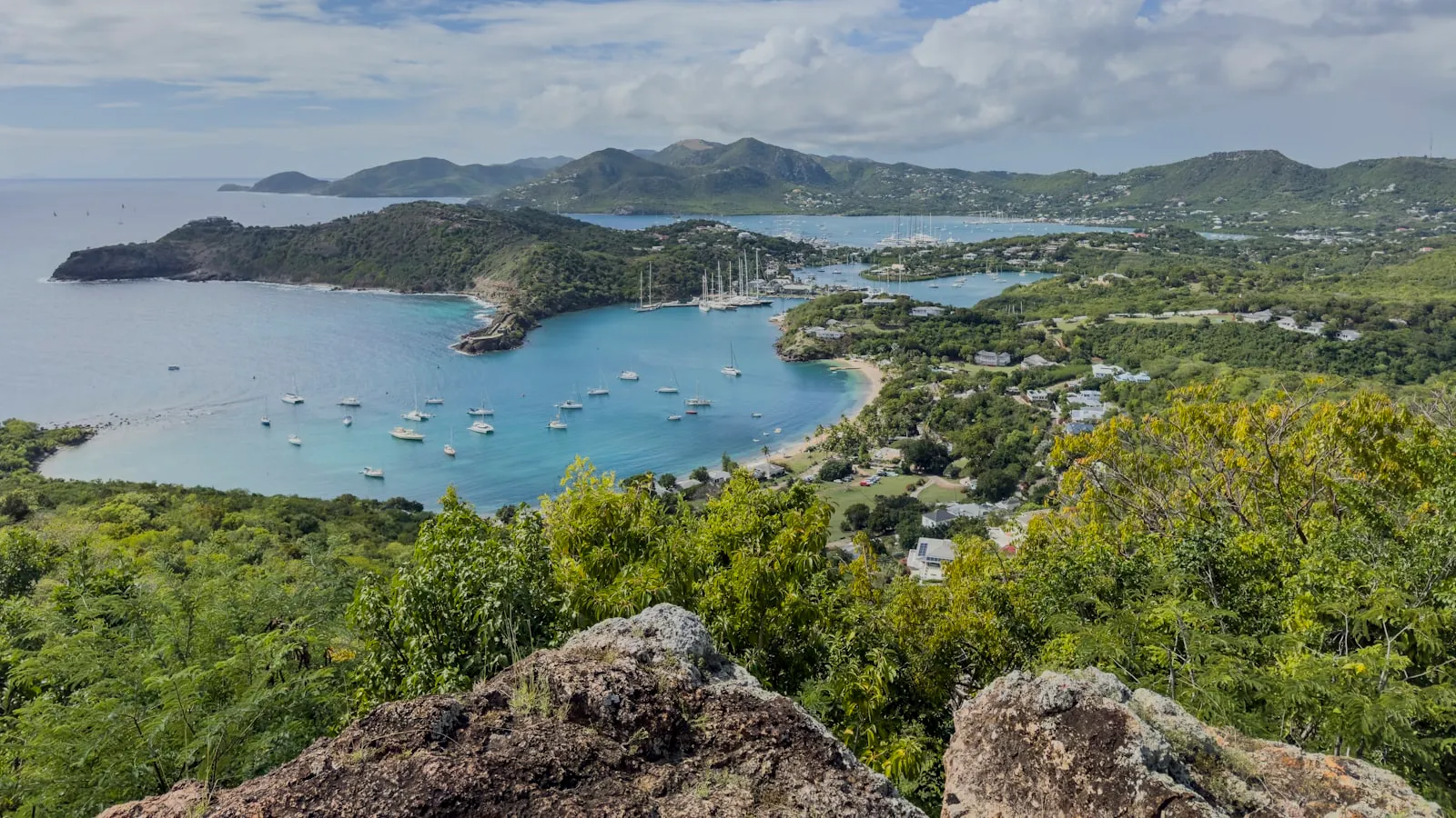 Boats anchored in a bay with lush green hills