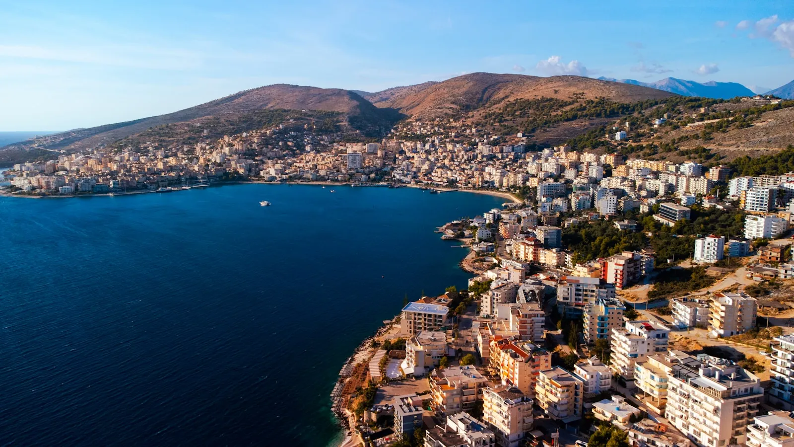 Aerial view of Saranda curving around a blue bay on the Albanian coast.