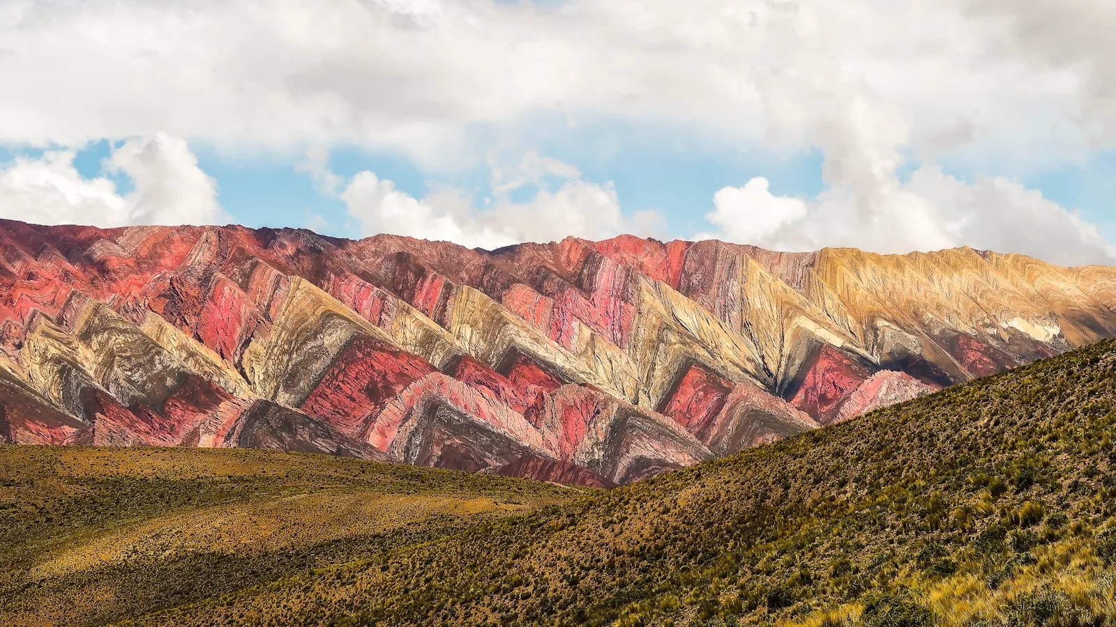 Brown and gray mountains under white clouds and blue sky during daytime