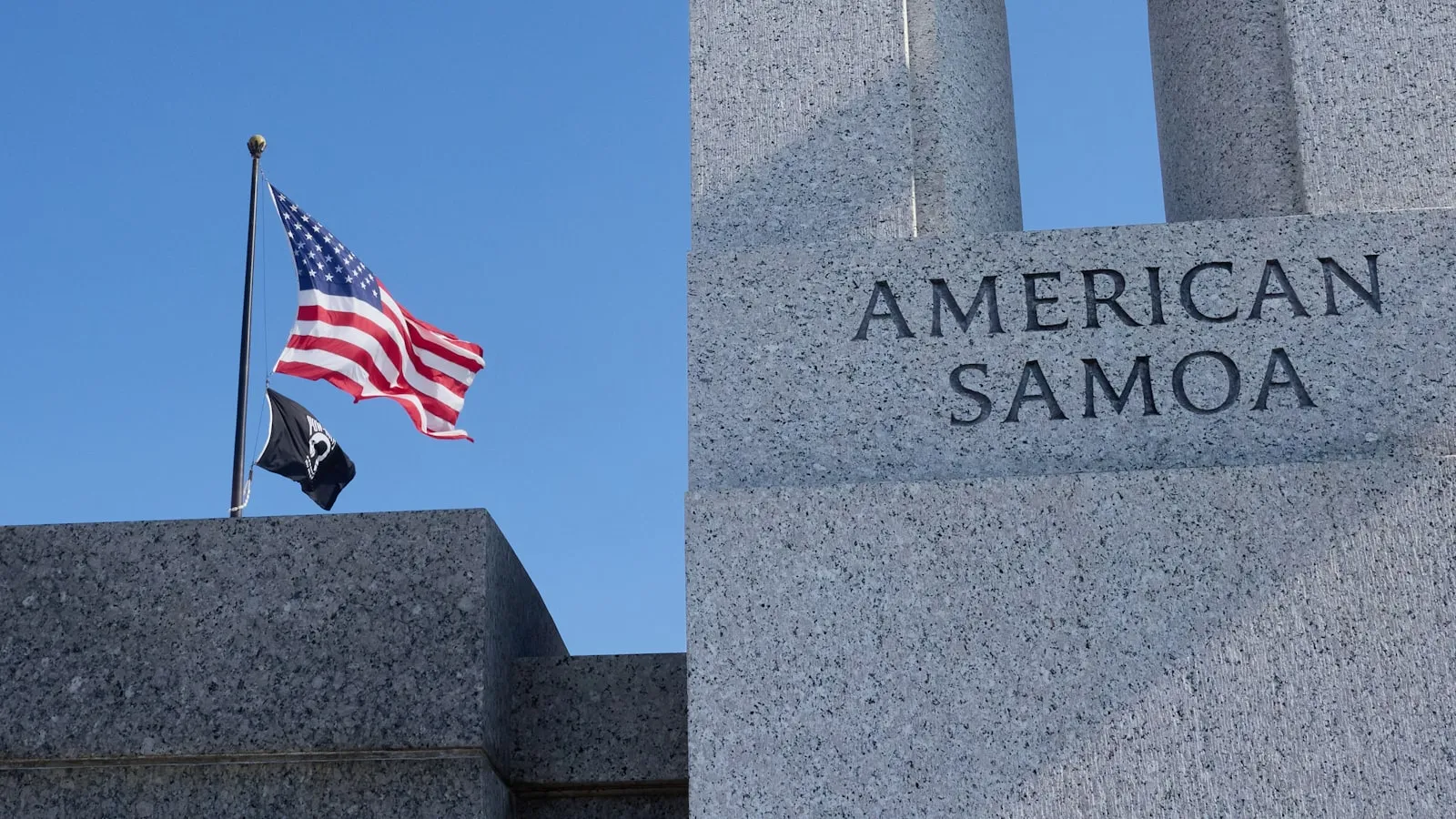 American flag flies half-mast near washington monument.