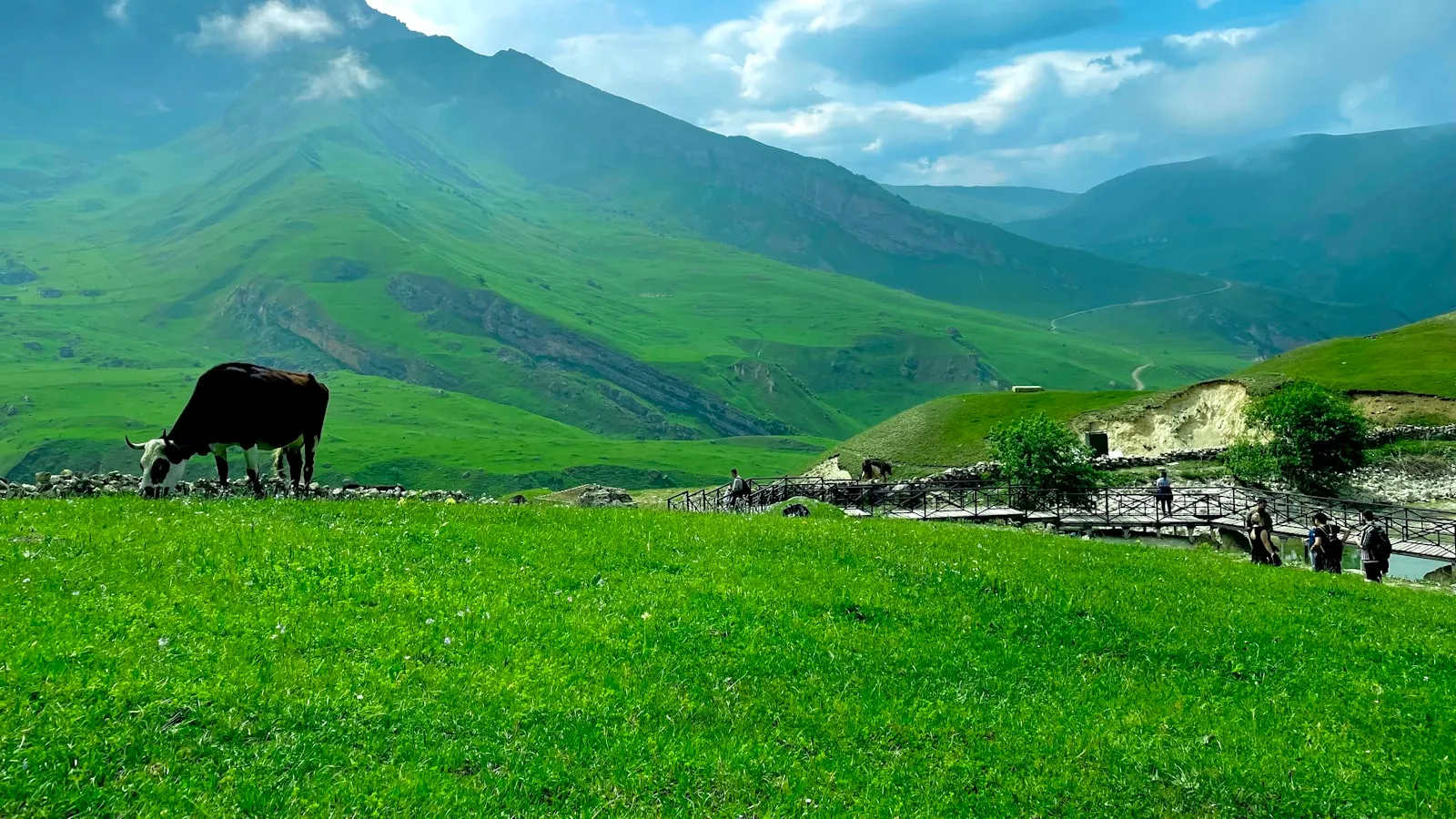 Green mountains under white clouds during daytime