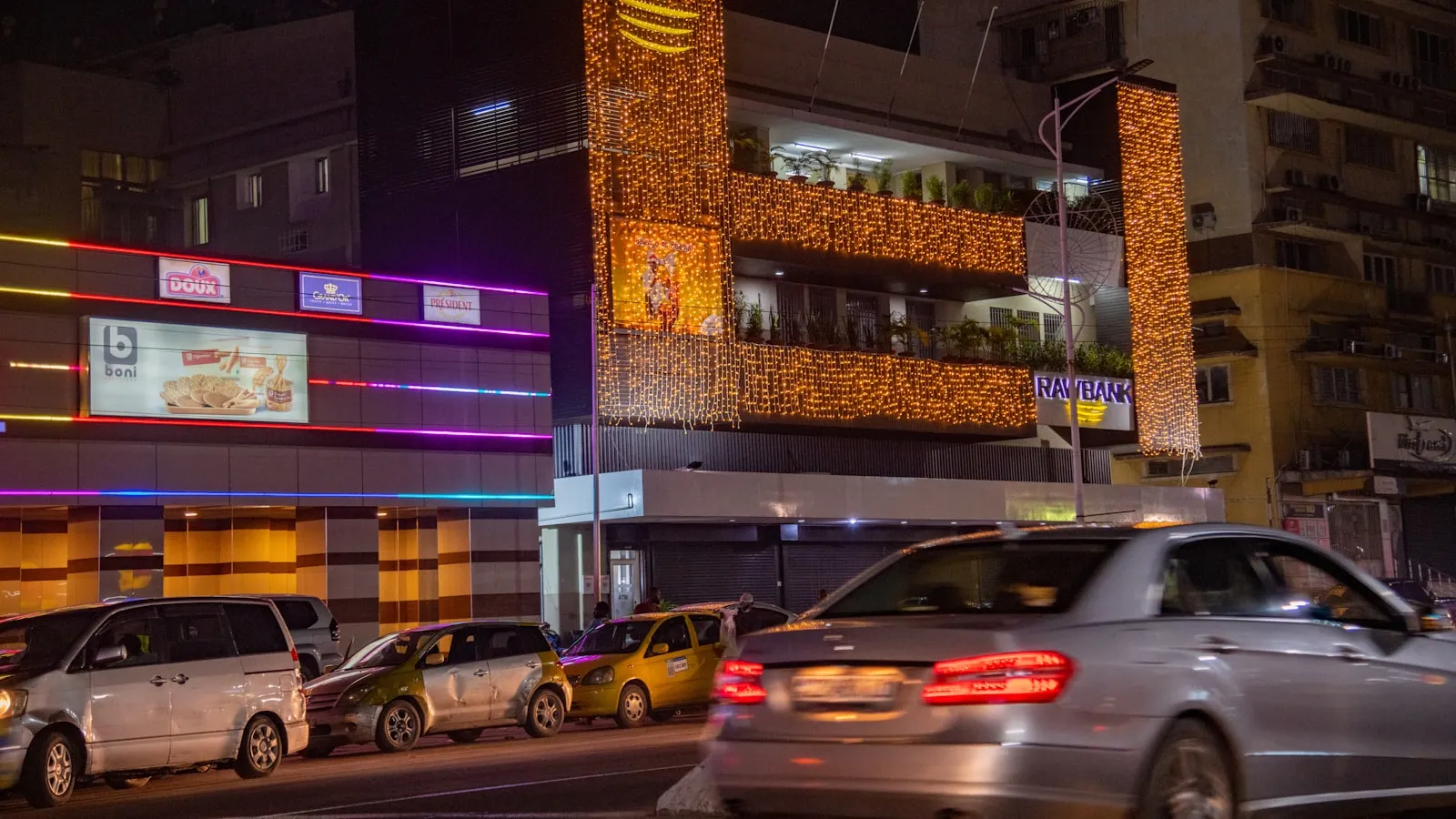 A city street filled with lots of traffic next to tall buildings