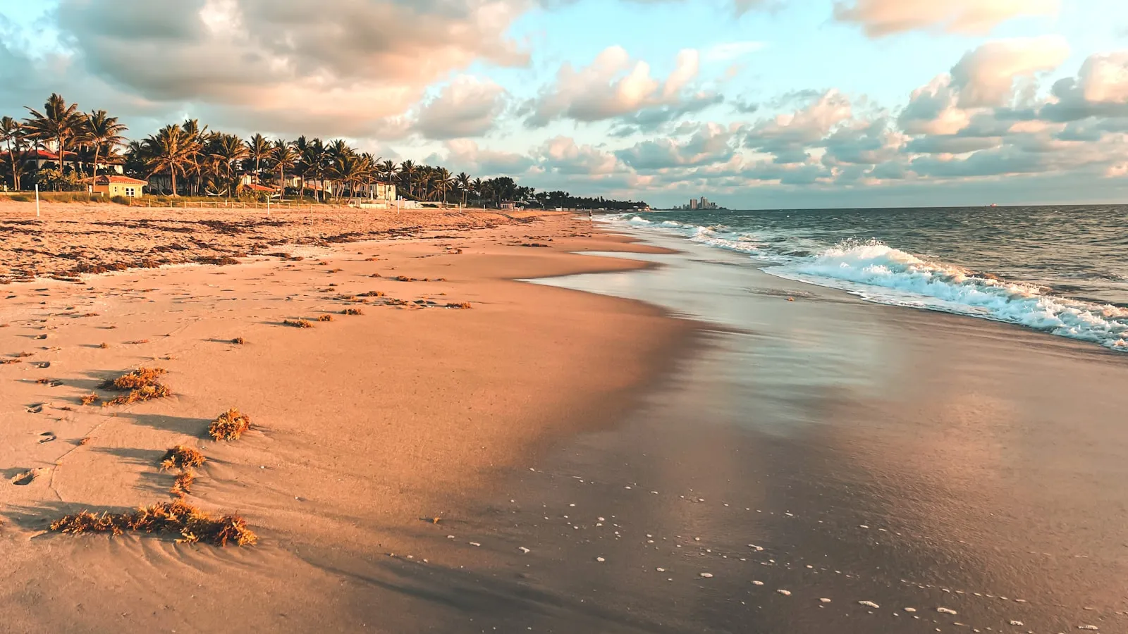 A sandy beach with waves coming in from the ocean