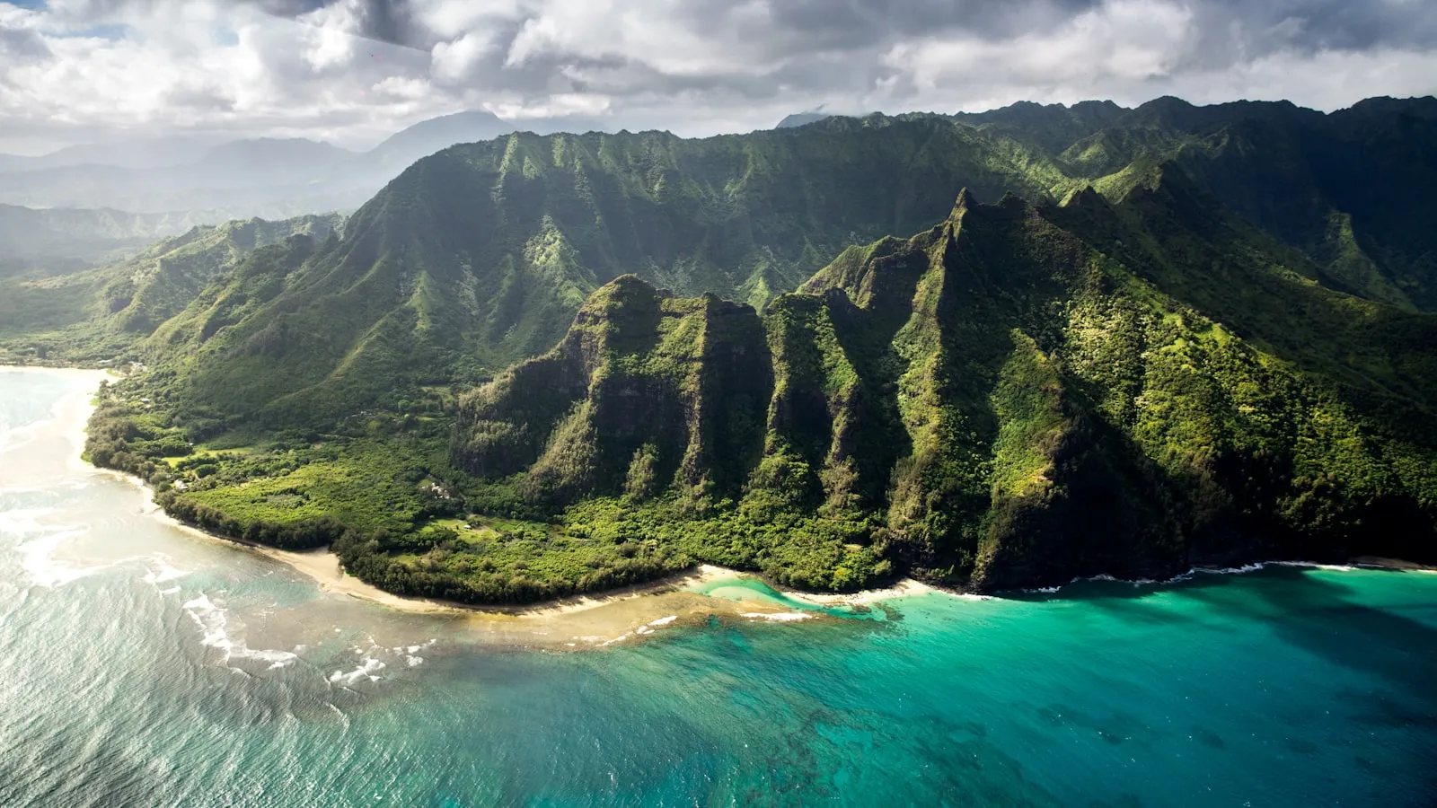 An aerial view of the lush green Na Pali Coast mountains in Kauai, Hawaii.
