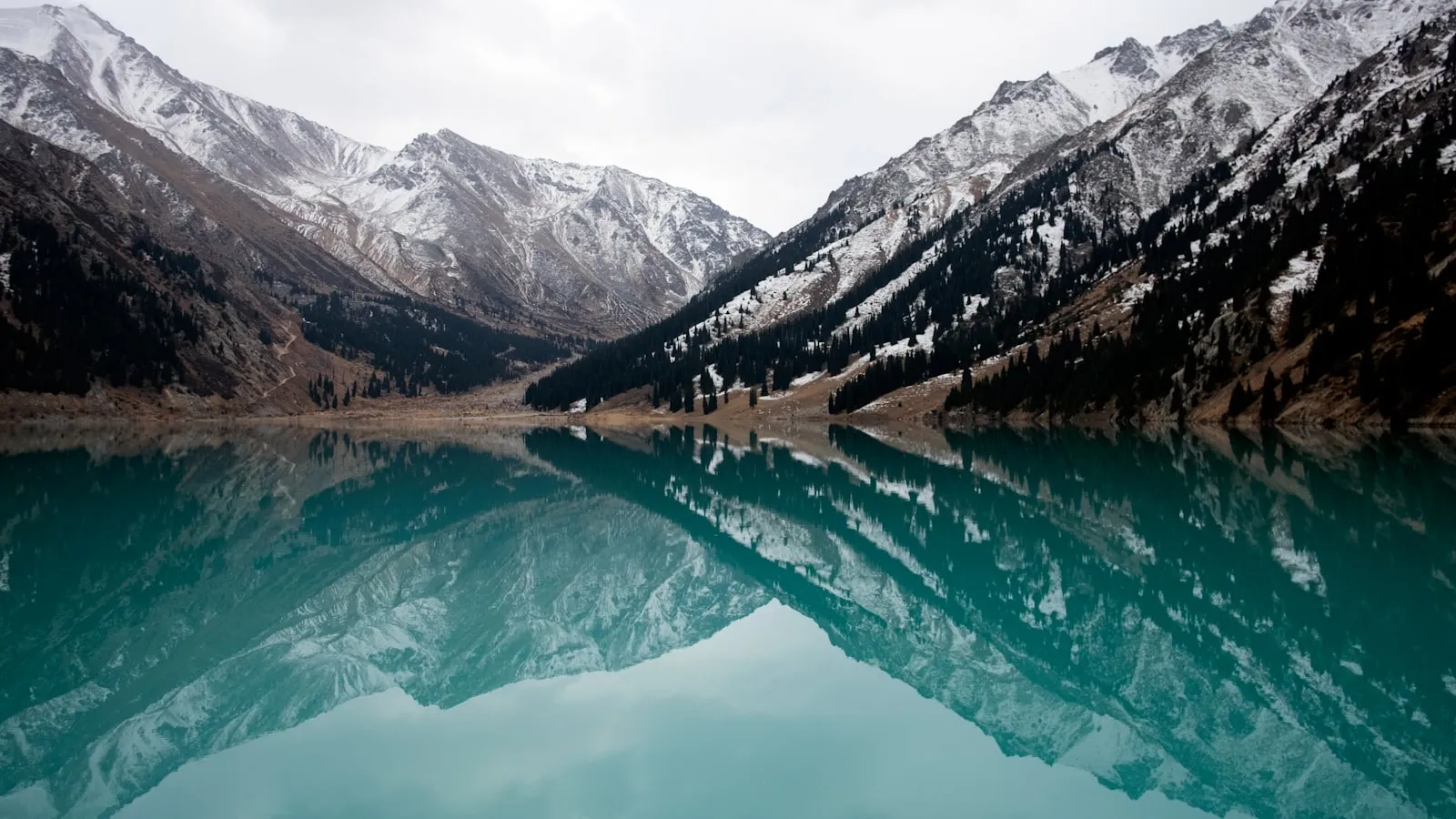 Lake surrounded with mountains during daytime