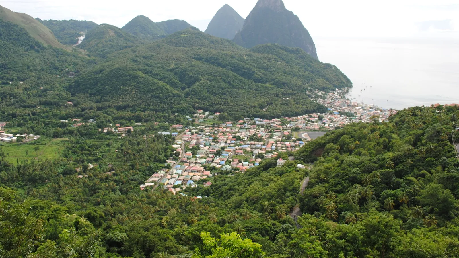 Houses on mountain near body of water during daytime