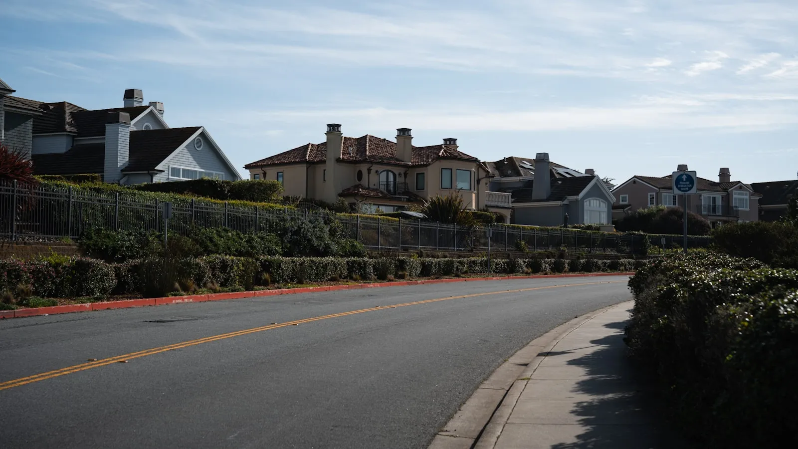 Suburban street with houses on a hill.