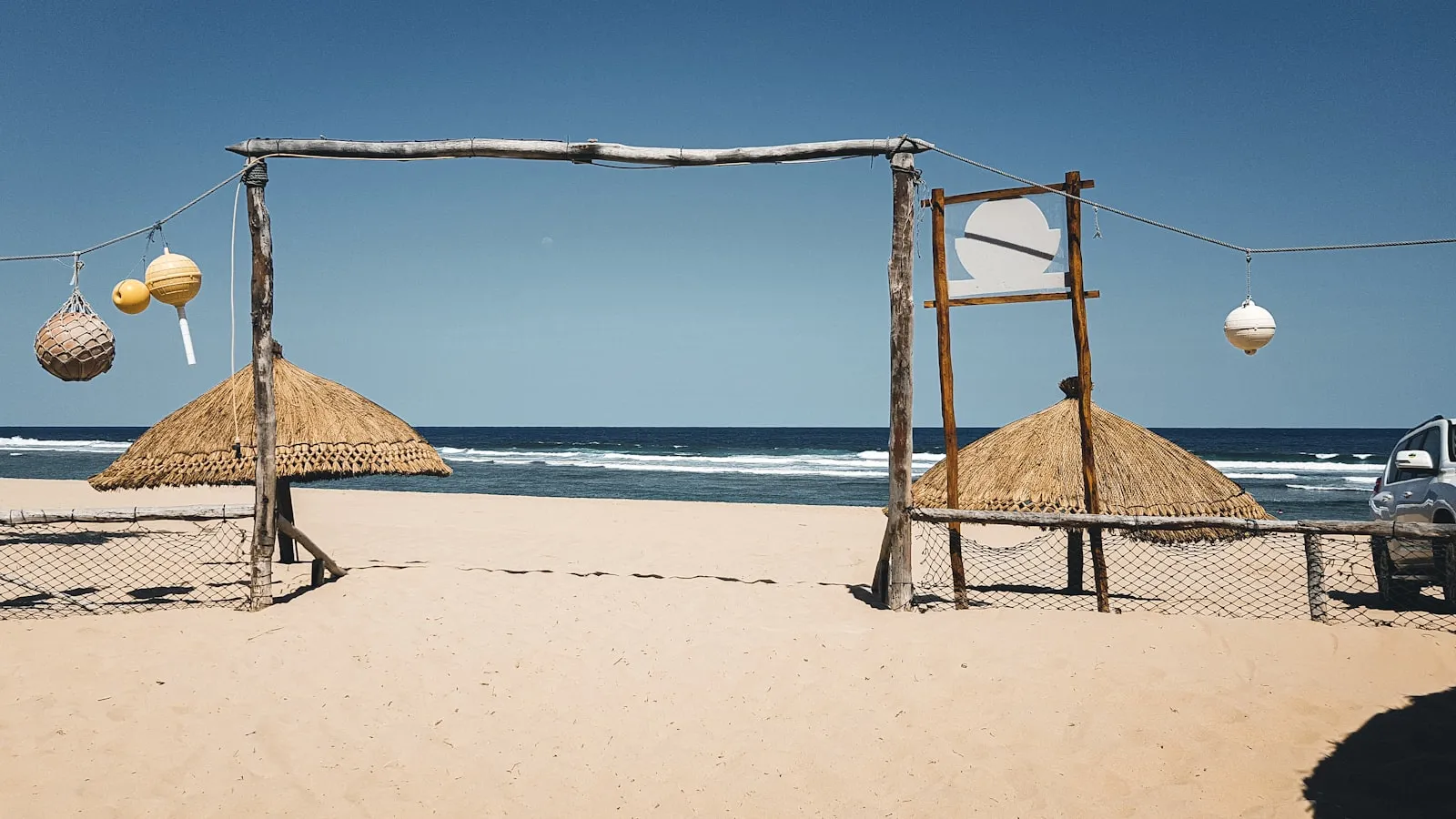 Brown wooden beach house on white sand beach during daytime