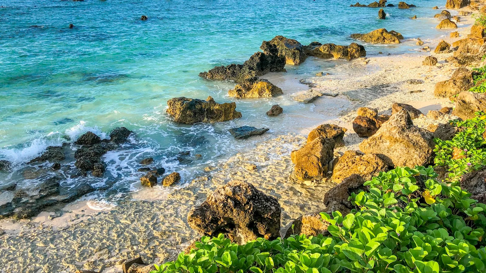 Sea water and rocks by the beach coast during daylight