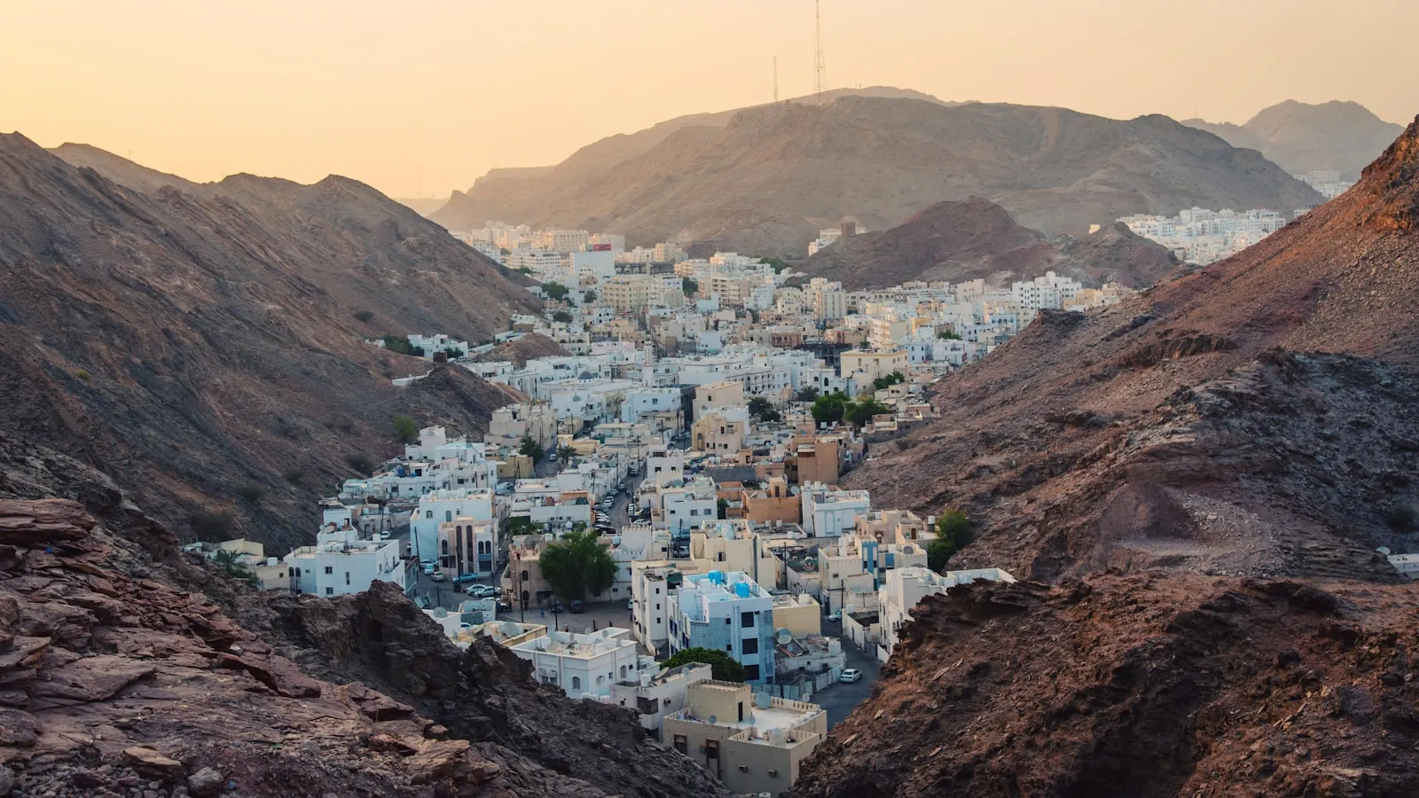 Aerial view of white concrete buildings near rock cliffs