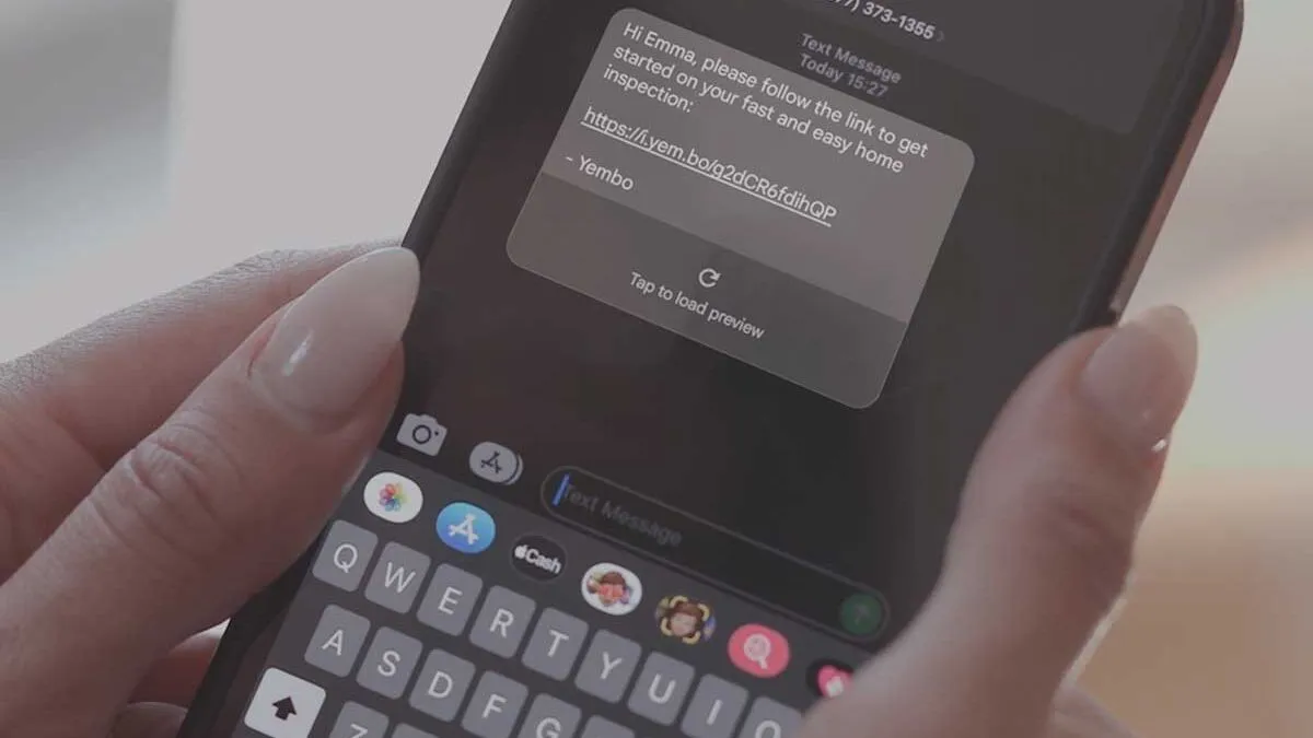 A policyholder reading a text message on a phone that links to their inspection.