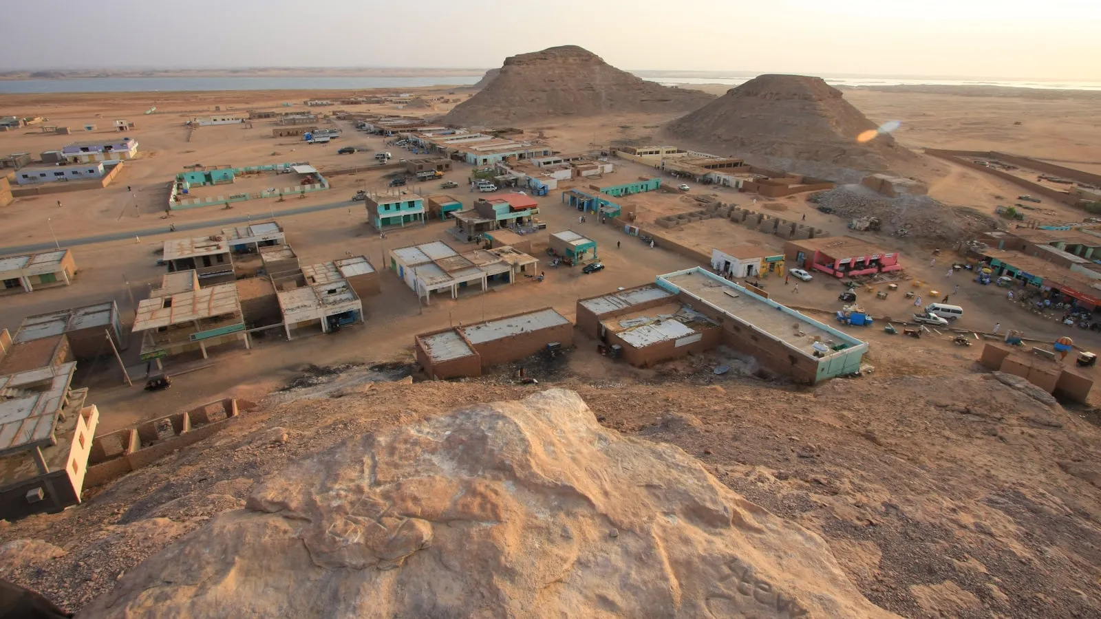 An aerial view of a desert town with a mountain in the background