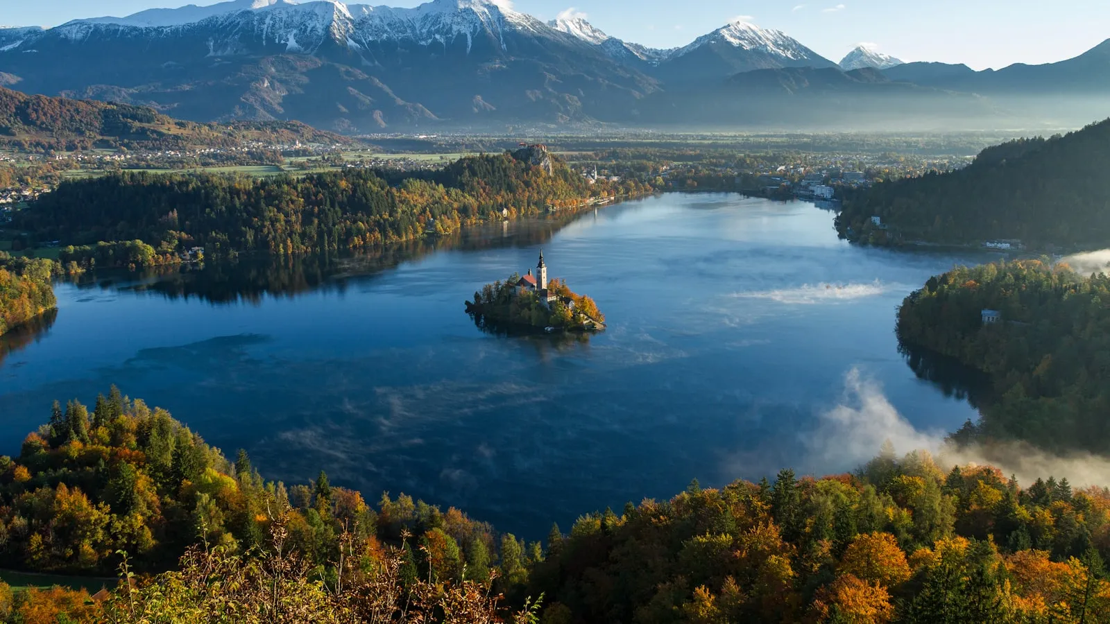Island surrounded by water and mountains at daytime