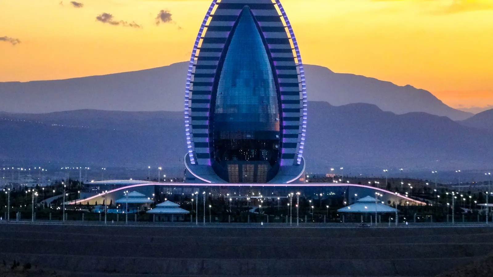 Modern building illuminated at sunset with mountains background