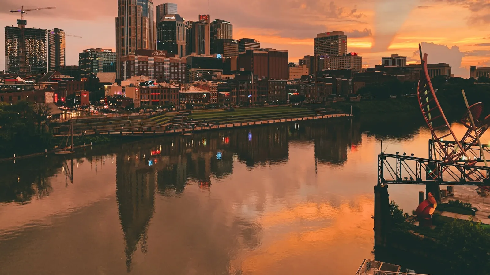 Body of water near city buildings during sunset