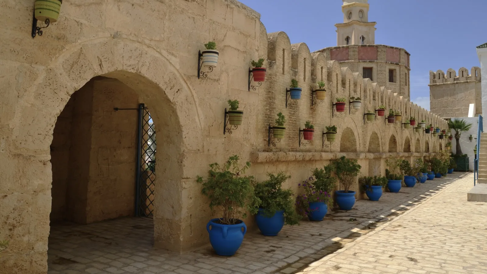 A stone building with blue potted plants in front of it