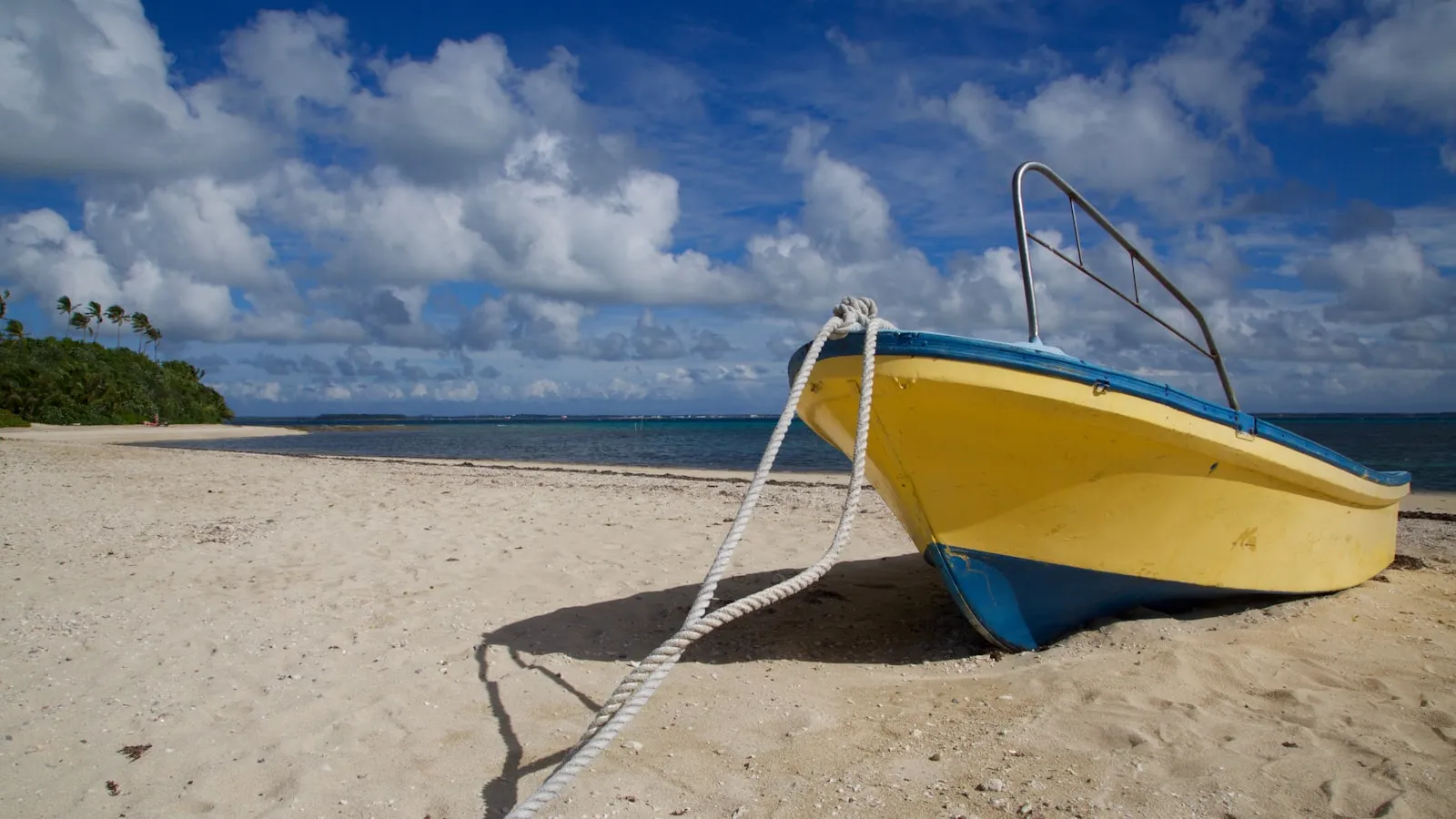 Yellow and blue cuddy boat on seashore