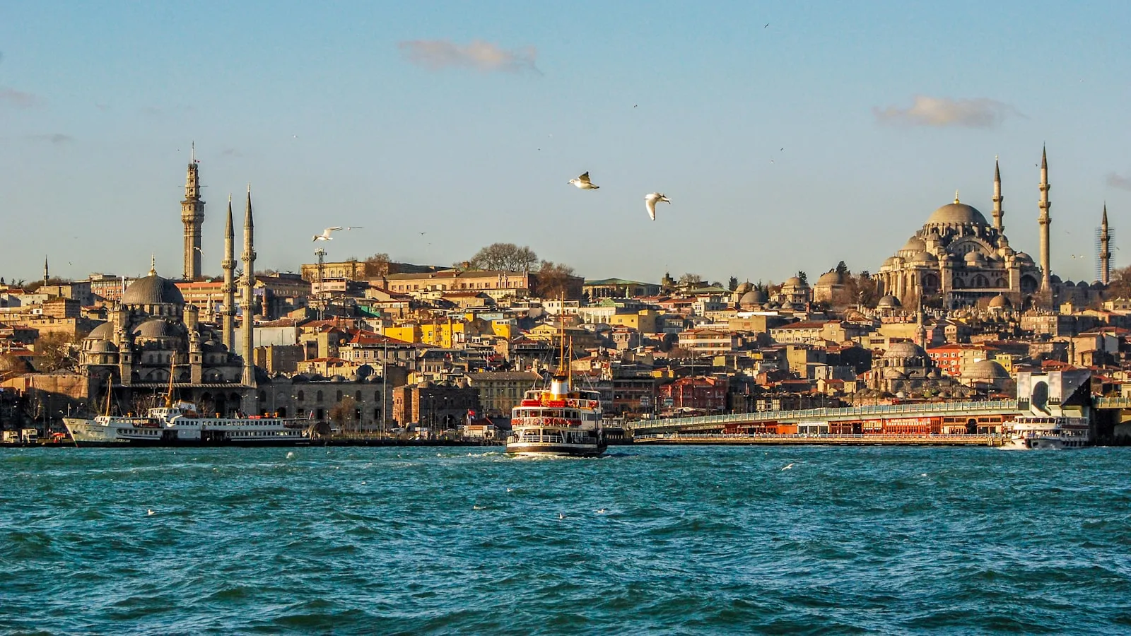 A ferry crossing the Bosphorus with the skyline of Eminönü, Istanbul, in the background.