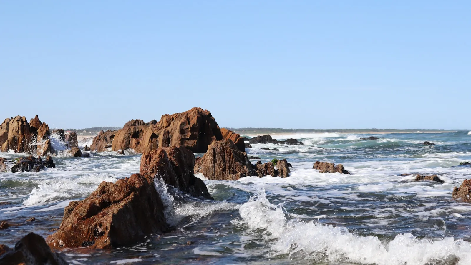 Brown rock formation on sea during daytime